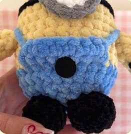 The characteristic emblem on the overalls is shown here for embroidery or crochet guidance. A real free pattern is available on the website, but this image is shared only as a transparent reference for the logo. You are invited to our blog to add this professional touch to your project.