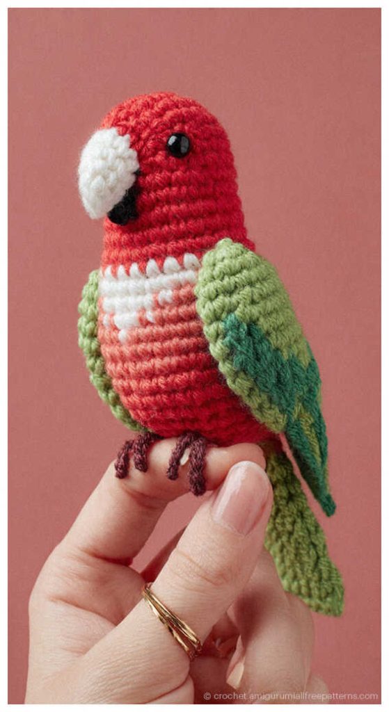 Realistic red and green crochet parrot held in hand, detailed bird amigurumi inspiration for handmade home decor